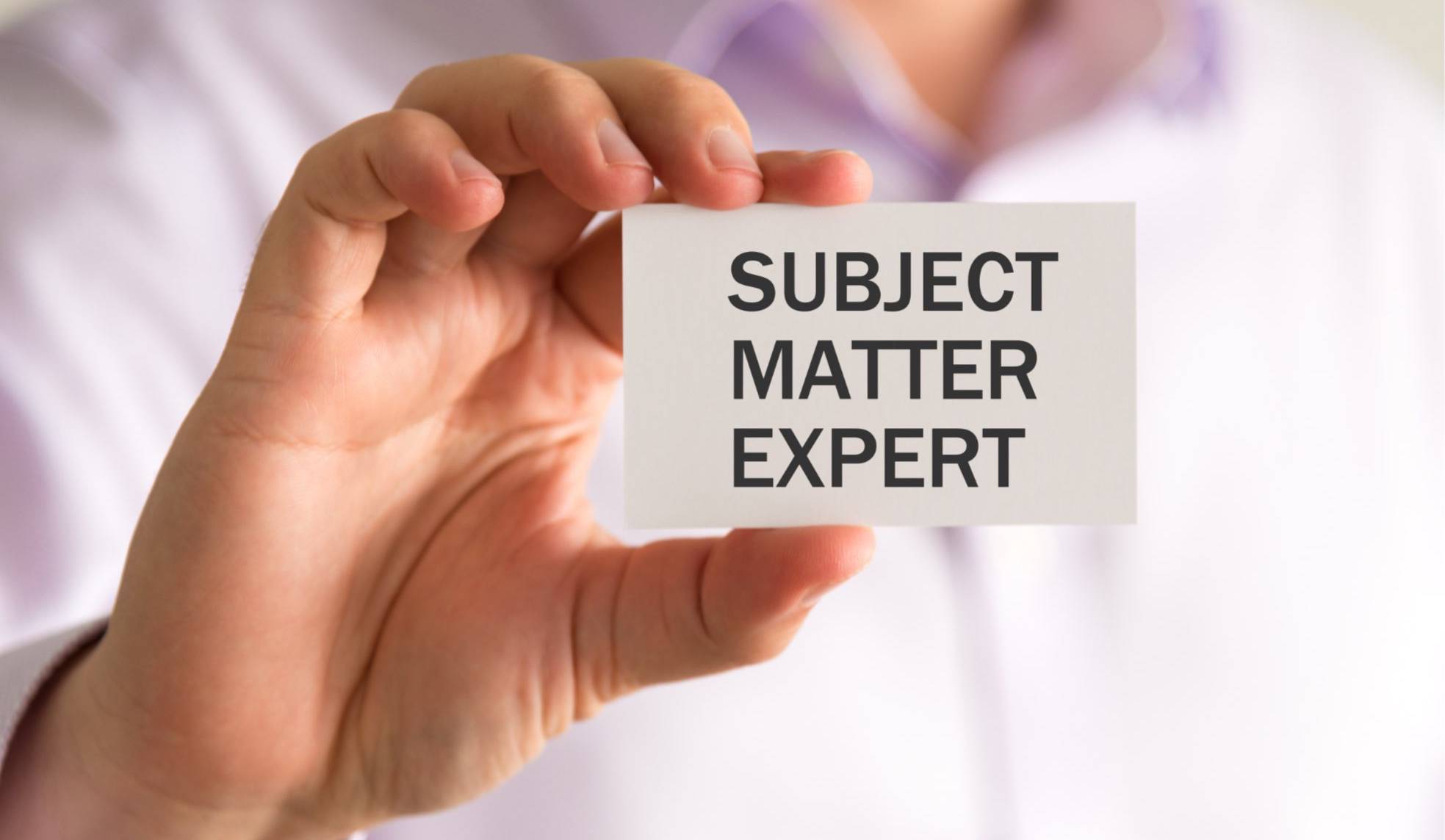 A man holding a business card that says Subject Matter Expert