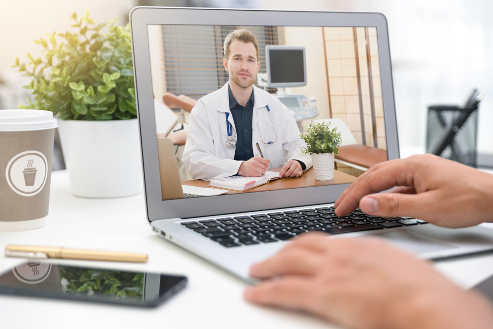 A patient connects online with a male physician to get a checkup via telemedicine services.