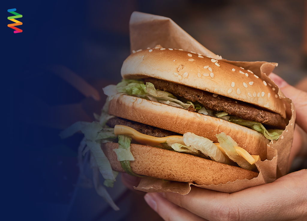 Close up of hand holding a McDonalds Big Mac burger.